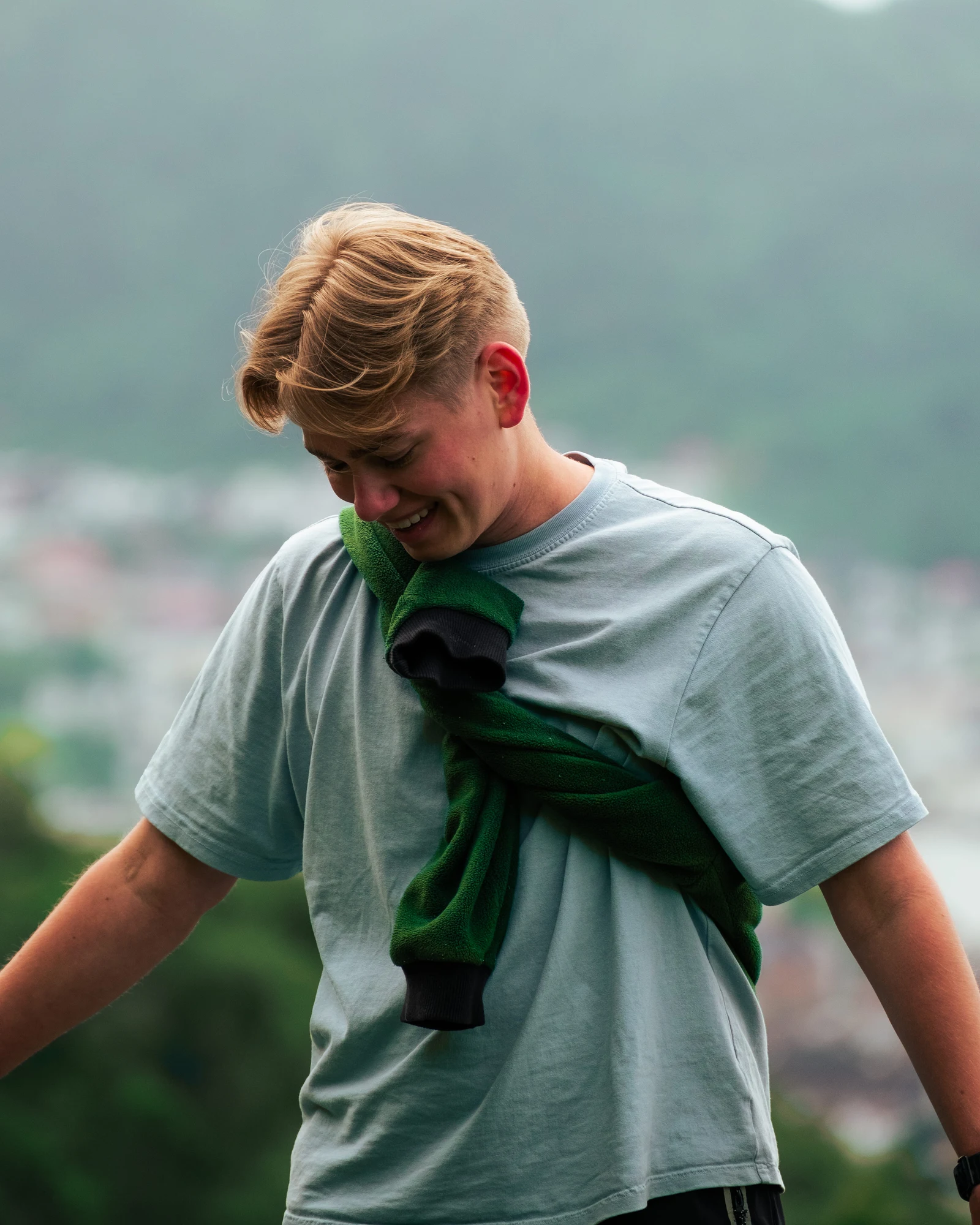 A person looking down with a sweatshirt draped over their shoulders