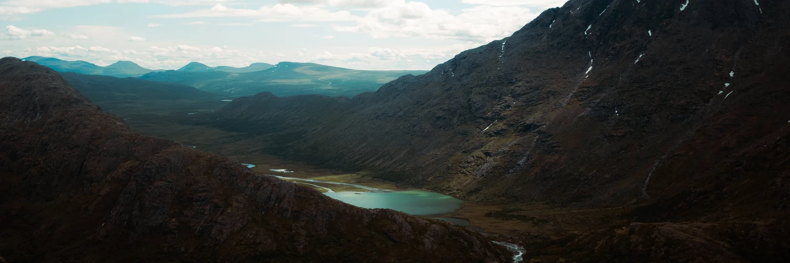 Dark rocky mountain slopes above a bright turquoise lake