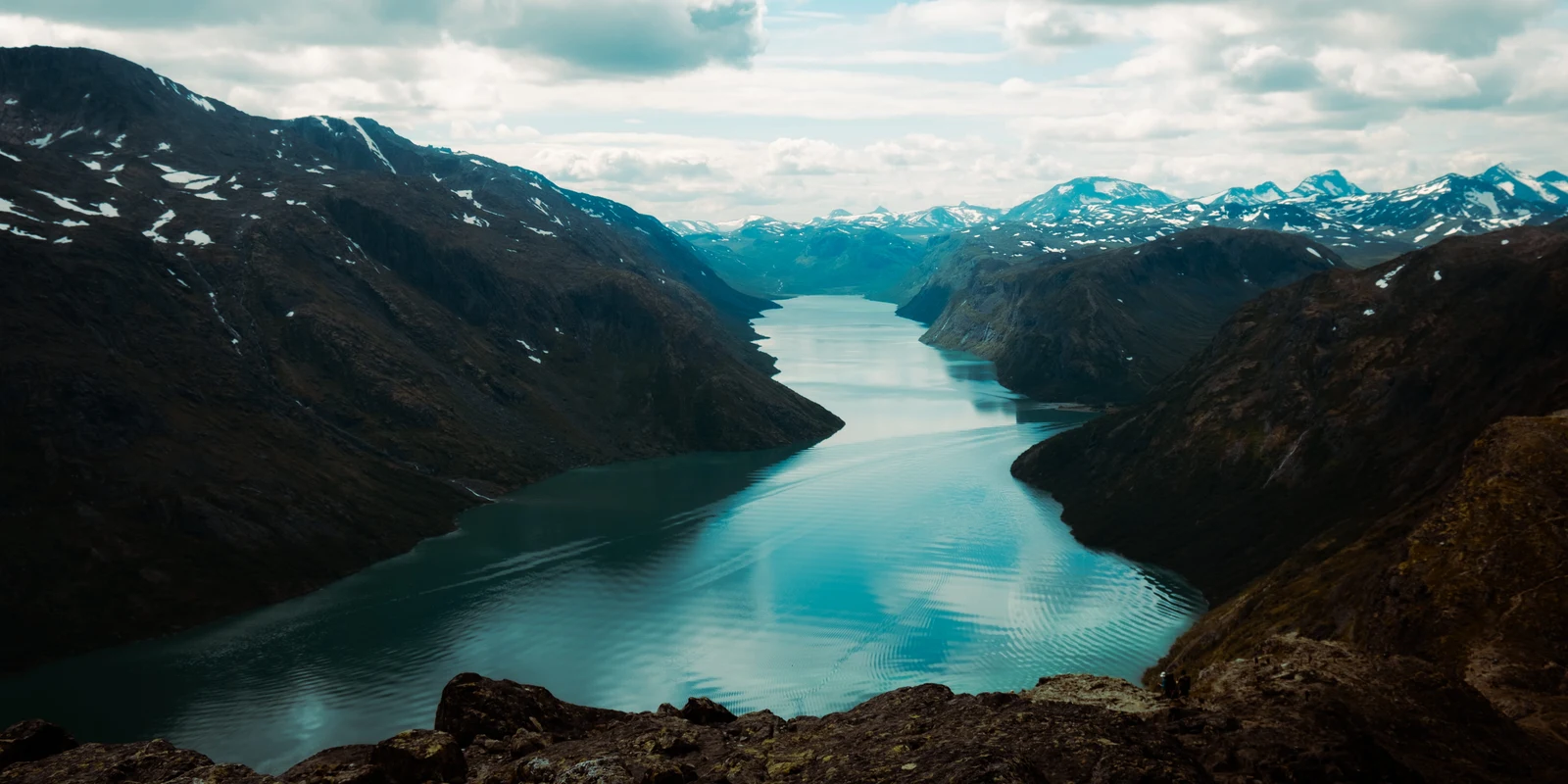 A mountain ridge reflected in a calm turquoise lake