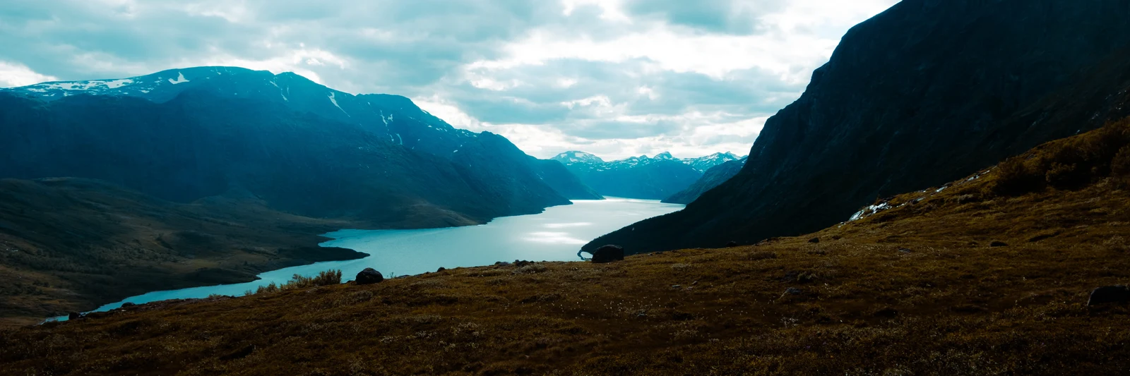 Two blue lakes separated by a dark mountain ridge