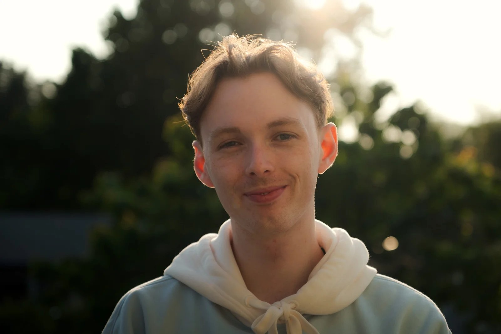 areal alien outdoors in a light hoodie with warm backlighting