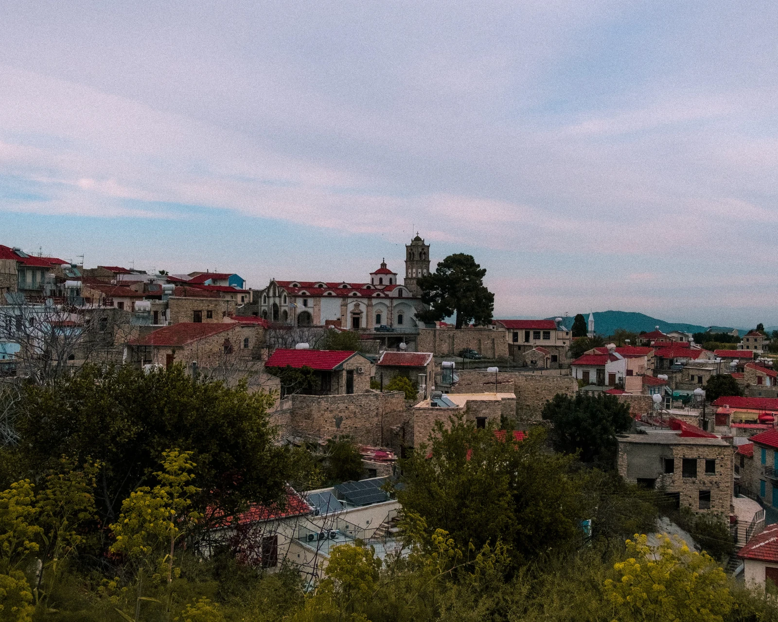 A cluster of pale stone buildings and a tower on a hillside