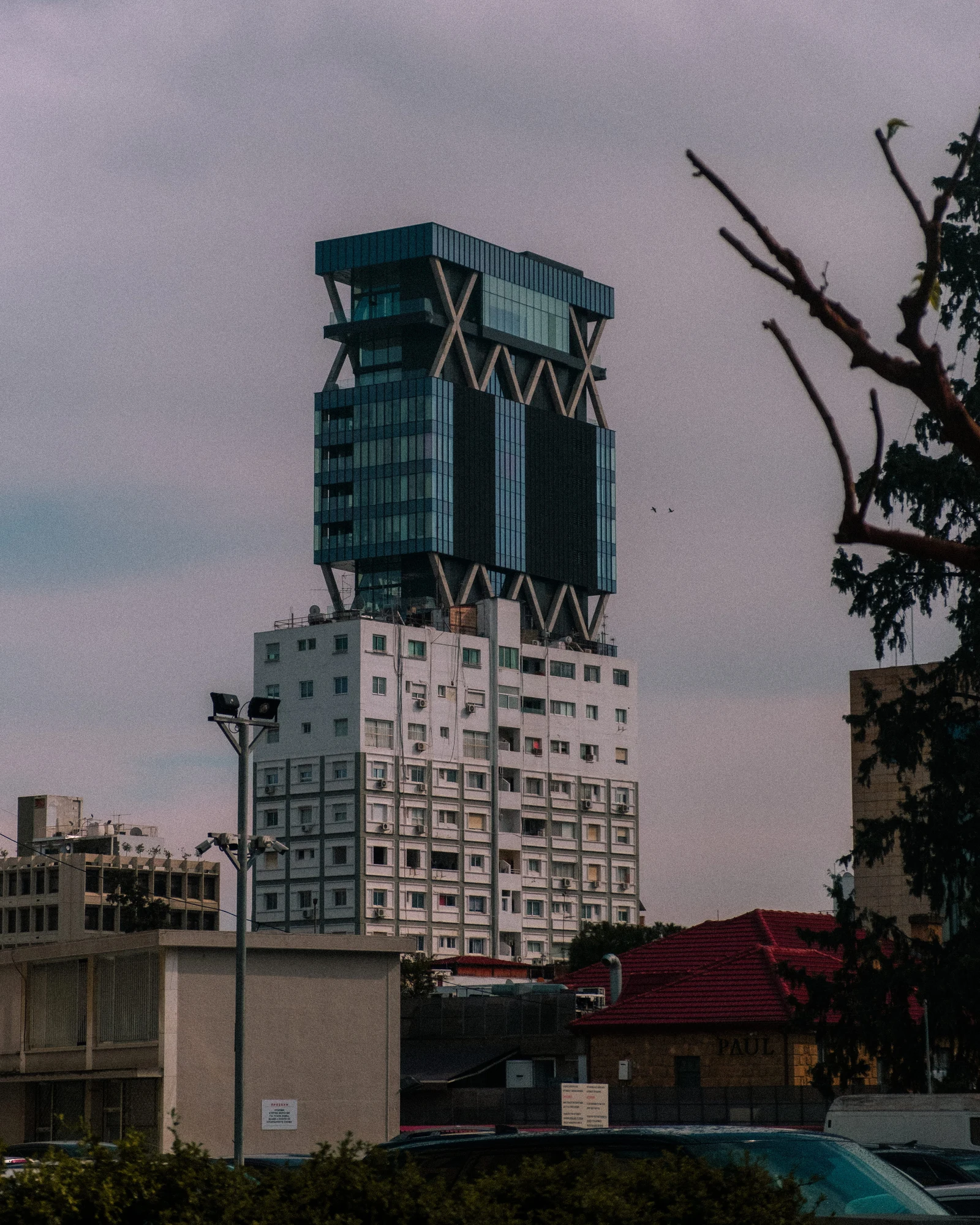 A geometric high-rise tower above low city rooftops