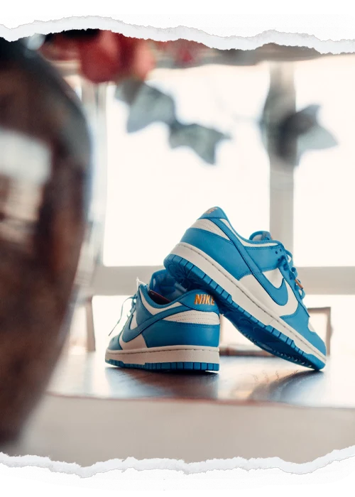 Blue and white sneakers framed by a torn-paper photographic border