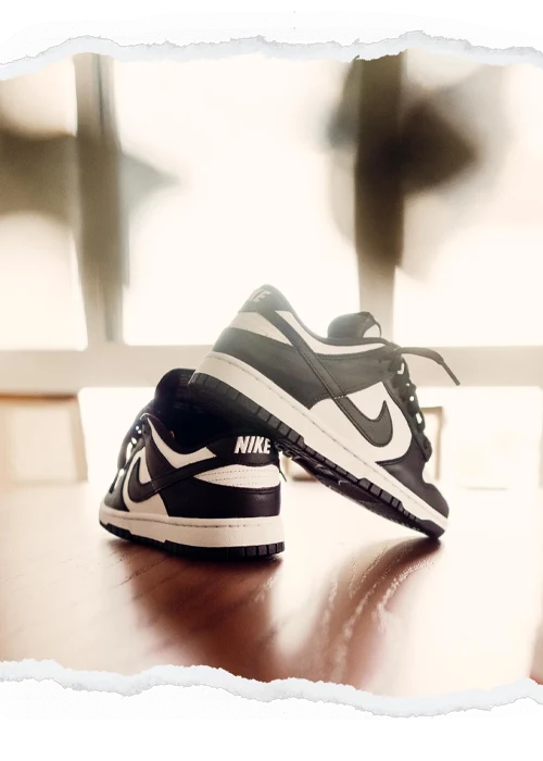 Black and white sneakers framed by a torn-paper photographic border